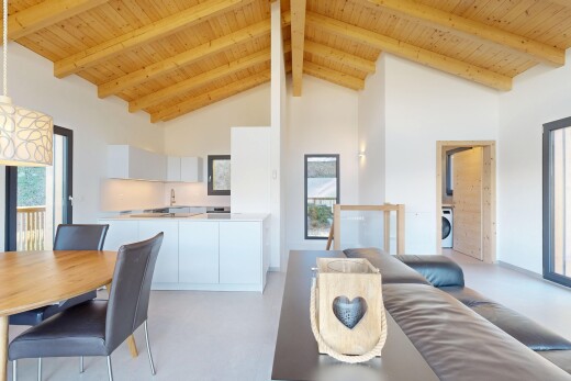 living area with plenty of natural light, concrete floors, and a high wooden beamed ceiling