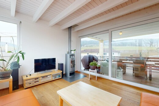 wohnzimmer mit holzfußboden, natürliches licht, fernseher, und balkendecke