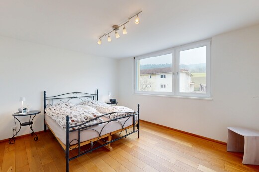 chambre avec cloison sèche, sol en finition bois, plinthes murales, lumière naturelle, et éclairage sur rail