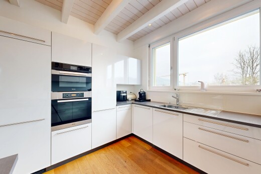 küche mit weiße schränke, natürliches licht, doppel backofen, waschbecken, und balkendecke