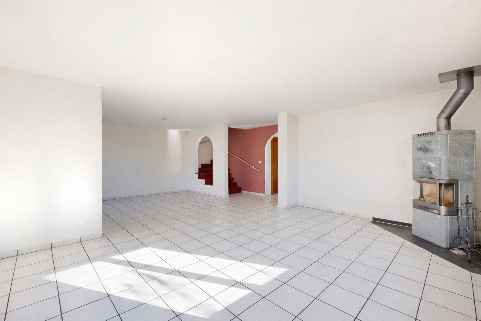pièce vide avec poêle à bois, passages en arc, inside property, drywall, et cloison sèche