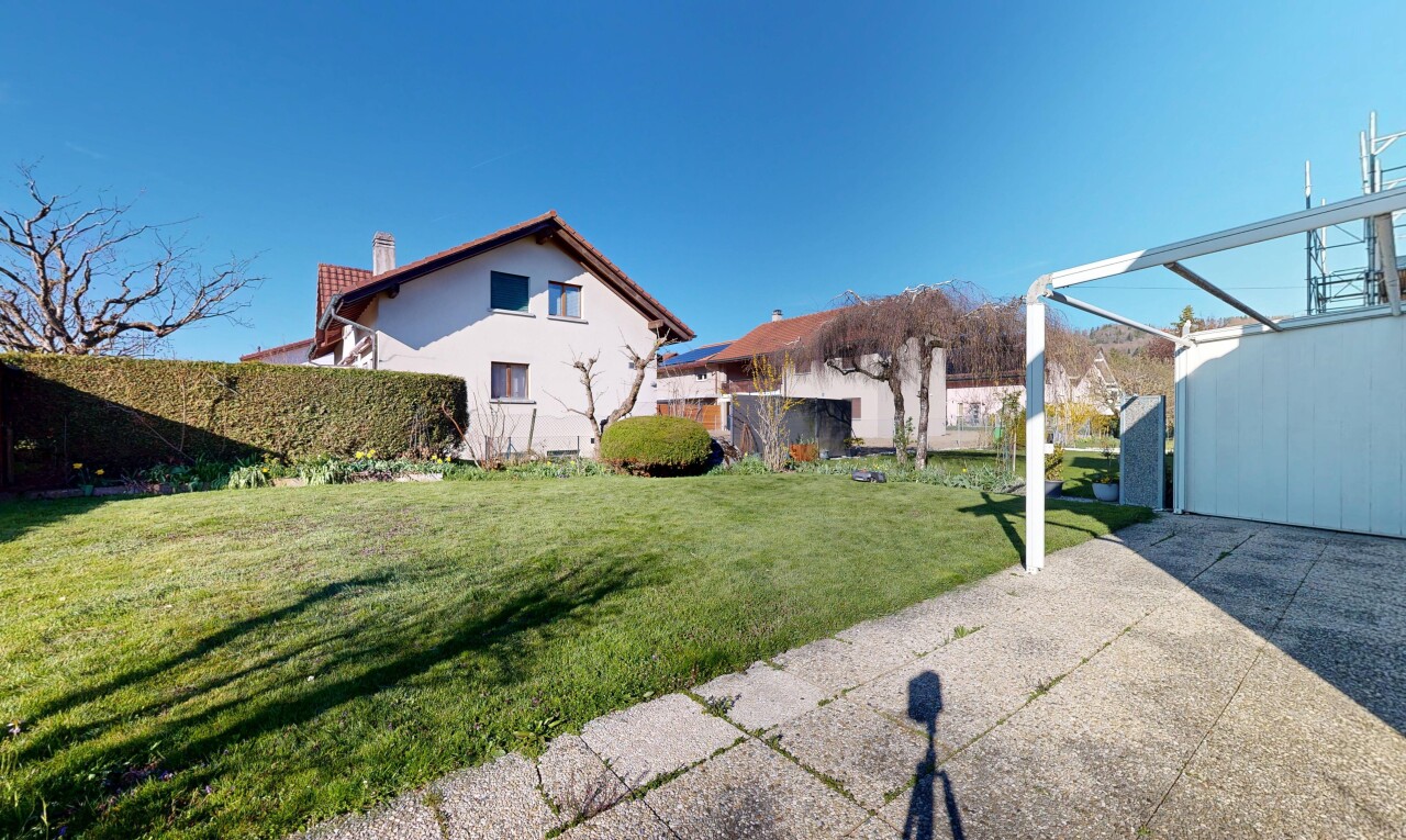 façade avec day time, cheminée, pelouse, property visible, et bardage en stuc