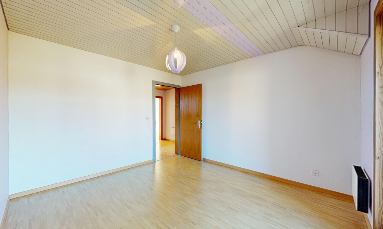 pièce vide avec sol en finition bois, wood finish floor, inside property, plafond voûté, et vaulted ceiling