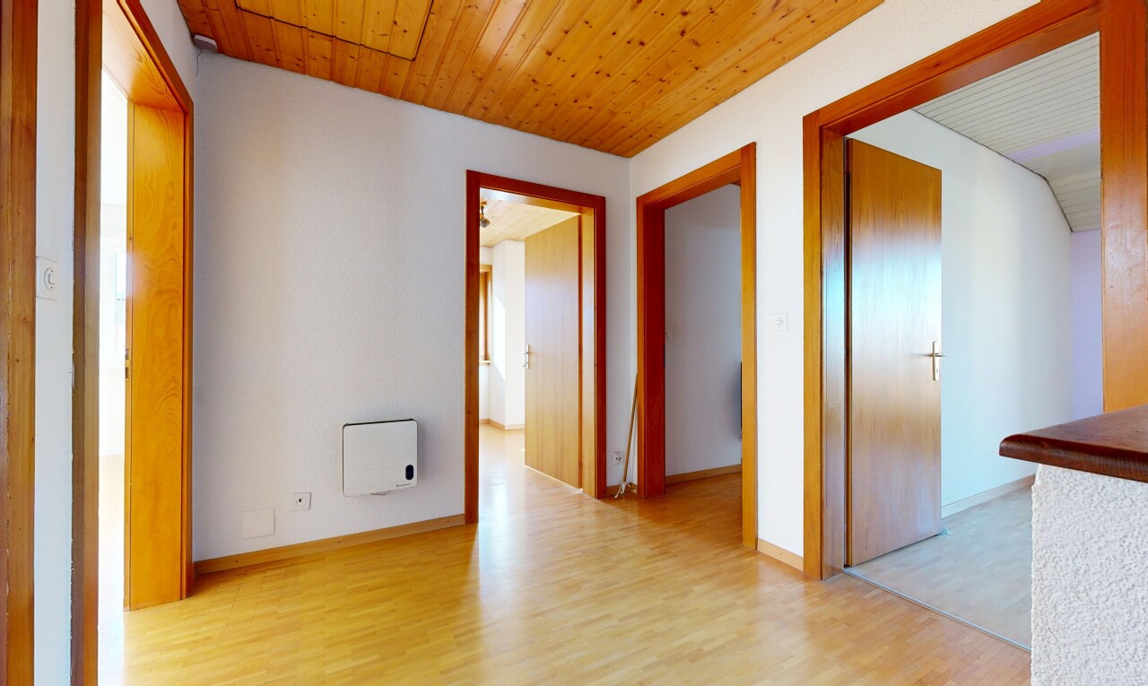 couloir avec wood finish floor, sol en finition bois, inside property, drywall, et cloison sèche