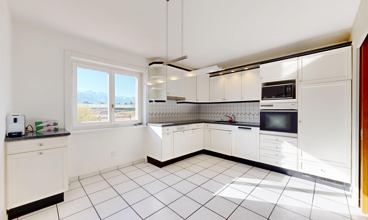 cuisine avec four, light floor, dark countertops, plans de travail, et white cabinets