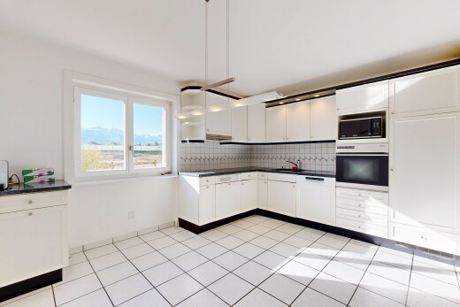 cuisine avec four, light floor, dark countertops, plans de travail, et white cabinets