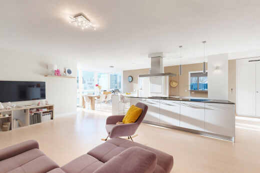 wohnzimmer mit fernseher, natürliches licht, gipskartonwand, und holzfußboden