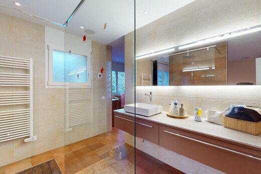 salle de bains avec évier, radiateur, chauffe-serviettes, douche, et mur en carrelage
