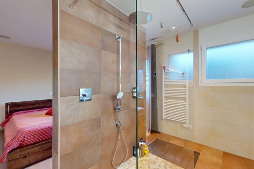 bathroom featuring connected bathroom, radiator, and walk in shower