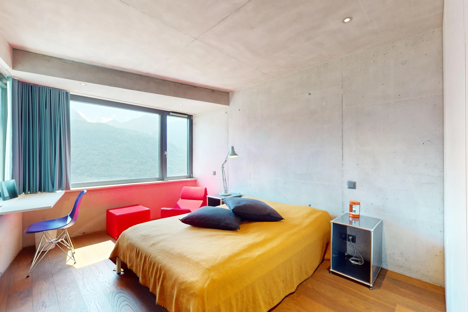 chambre avec plancher de bois, mur en béton, et lumière naturelle