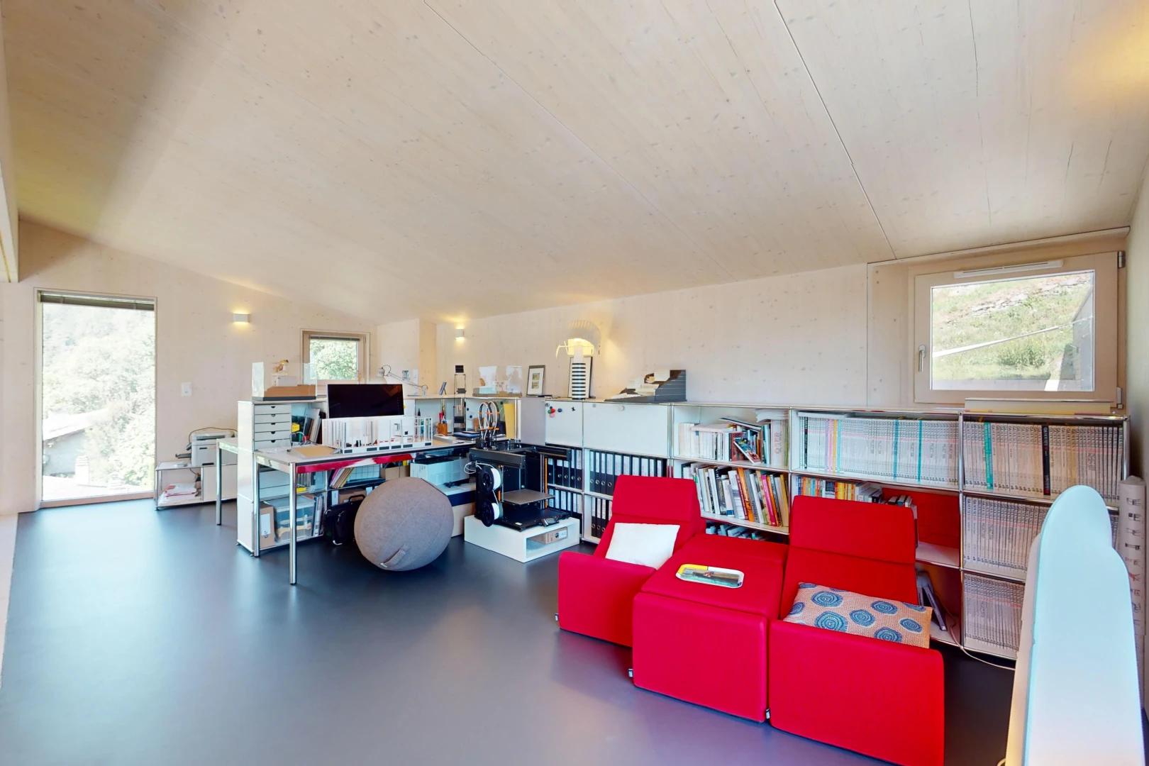 salon avec plafond voûté, sol en béton, lumière naturelle, et télévision