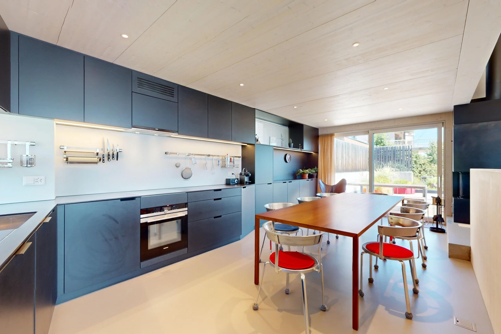 cuisine avec meubles bleus, four, meubles à panneaux plats, plan de travail, et lumière naturelle