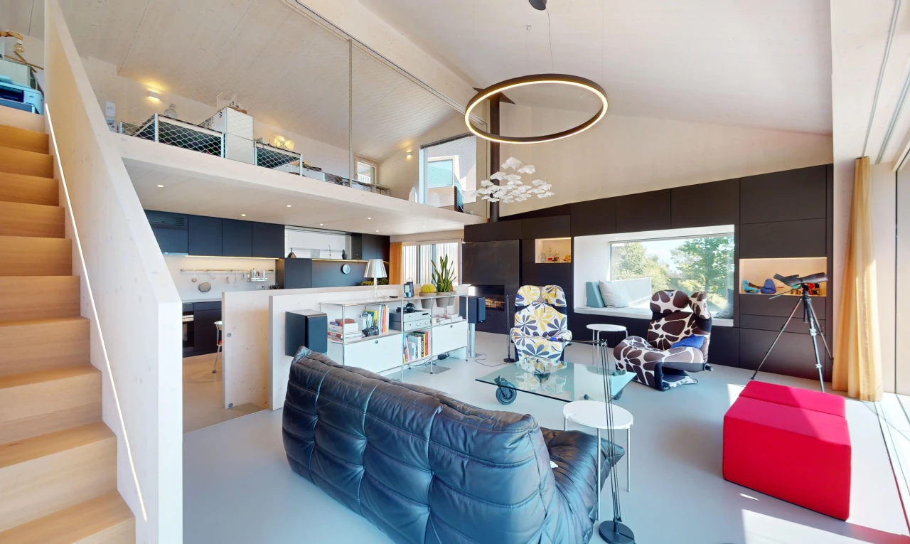 salon avec haut plafond, sol en béton, plafond voûté, et lumière naturelle