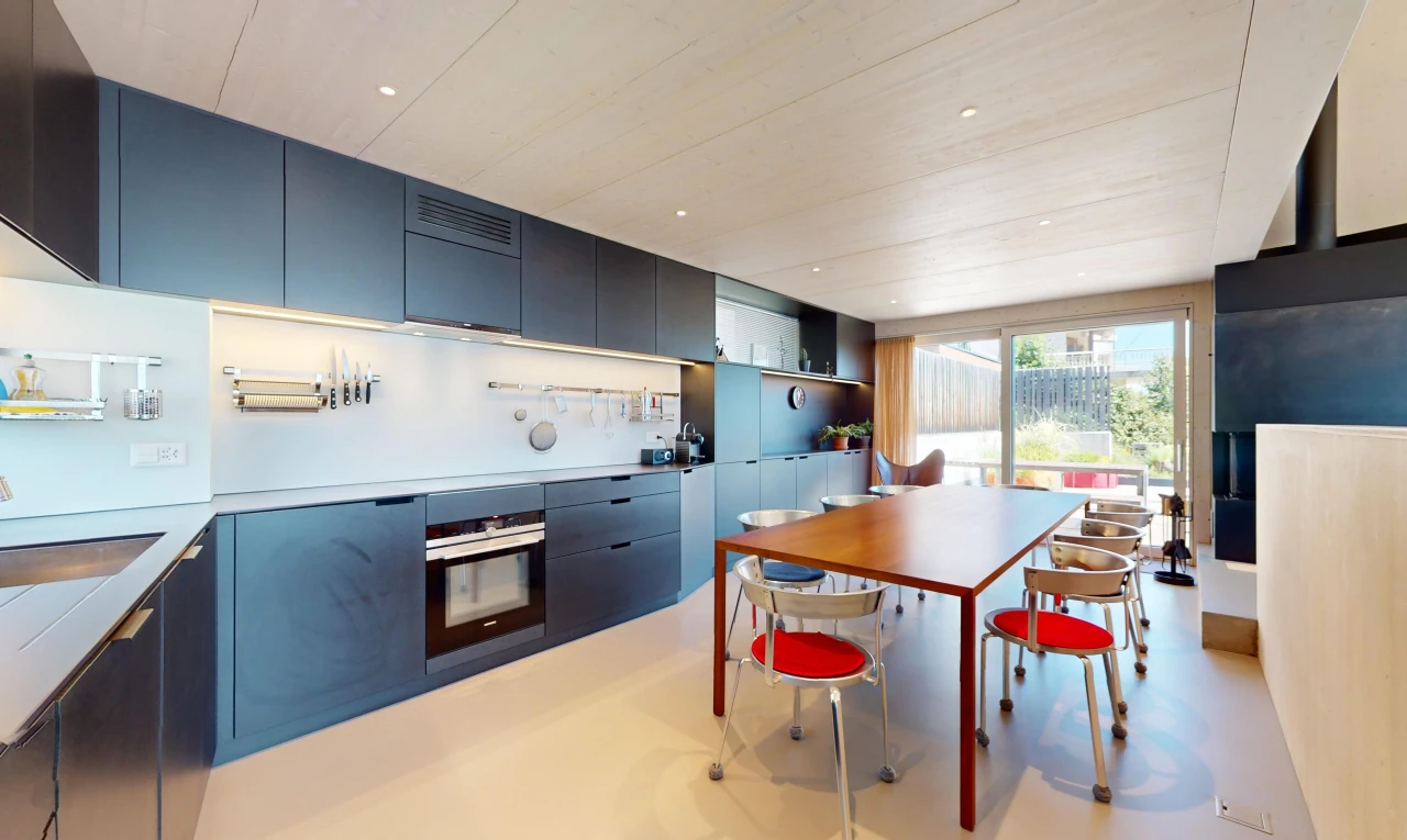 cuisine avec meubles bleus, four, meubles à panneaux plats, plan de travail, et lumière naturelle