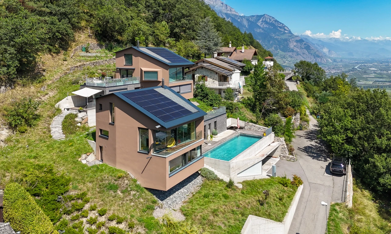 façade avec patio, panneaux solaires, piscine, et vue sur la montagne