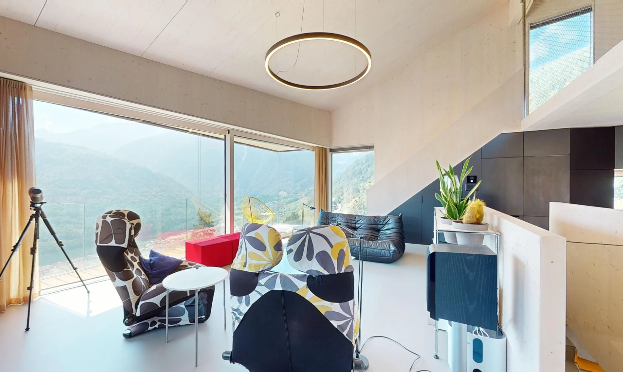 espace intérieur avec sol en béton, lumière naturelle, et vue sur la montagne
