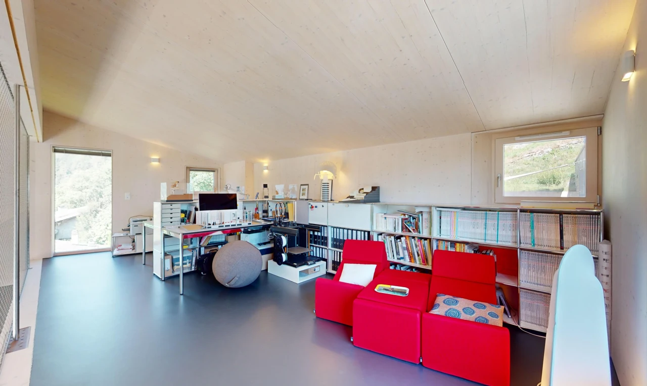 salon avec plafond voûté, sol en béton, lumière naturelle, et télévision