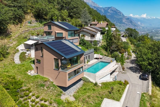 façade avec patio, panneaux solaires, piscine, et vue sur la montagne