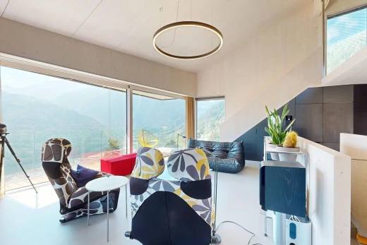 espace intérieur avec sol en béton, lumière naturelle, et vue sur la montagne