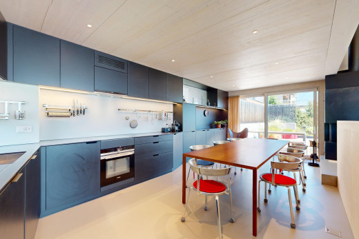 küche mit ofen, arbeitsplatten, natürliches licht, blaue schränke, und schränke mit flachen paneelen