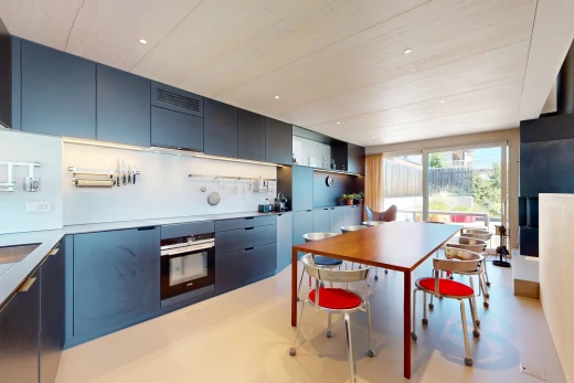 cuisine avec meubles bleus, four, meubles à panneaux plats, plan de travail, et lumière naturelle