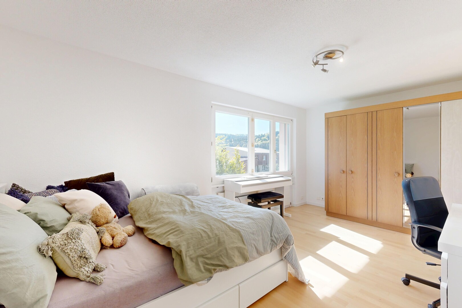 zimmer / schlafzimmer mit bürobereich, natural light, natürliches licht, wood finish floor, und holzfußboden