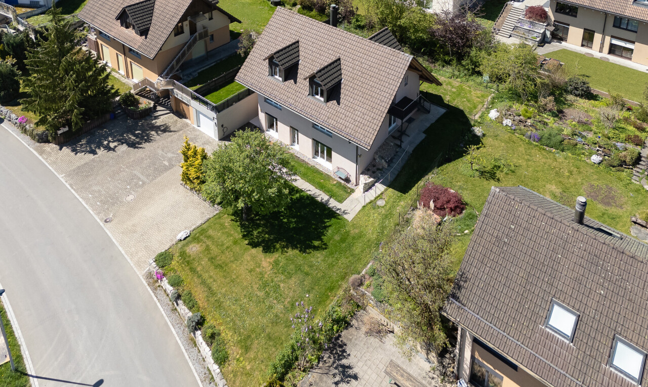 außenansicht mit garage, property visible, rasen, und auffahrt