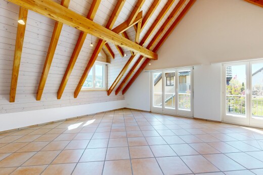 pièce vide avec beamed ceiling, plafond à poutres, vaulted ceiling, plafond voûté, et natural light