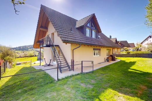 façade avec escaliers, property visible, clôture, pelouse, et bardage en stuc