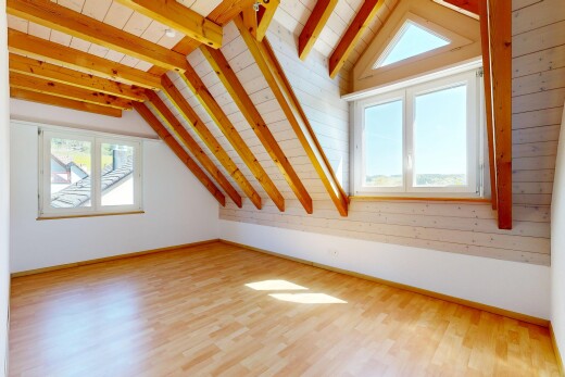 pièce vide avec beamed ceiling, plafond à poutres, wood finish floor, sol en finition bois, et natural light