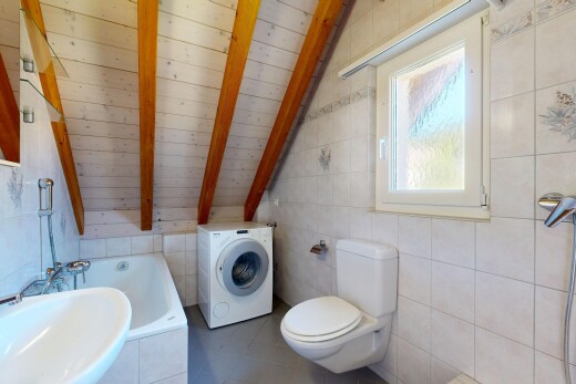 salle de bains avec vaulted ceiling, plafond voûté, toilette, lave-linge et sèche-linge, et salle de bain complète