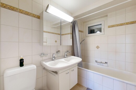 salle de bains avec tile wall, mur en carrelage, miroir, toilette, et inside property