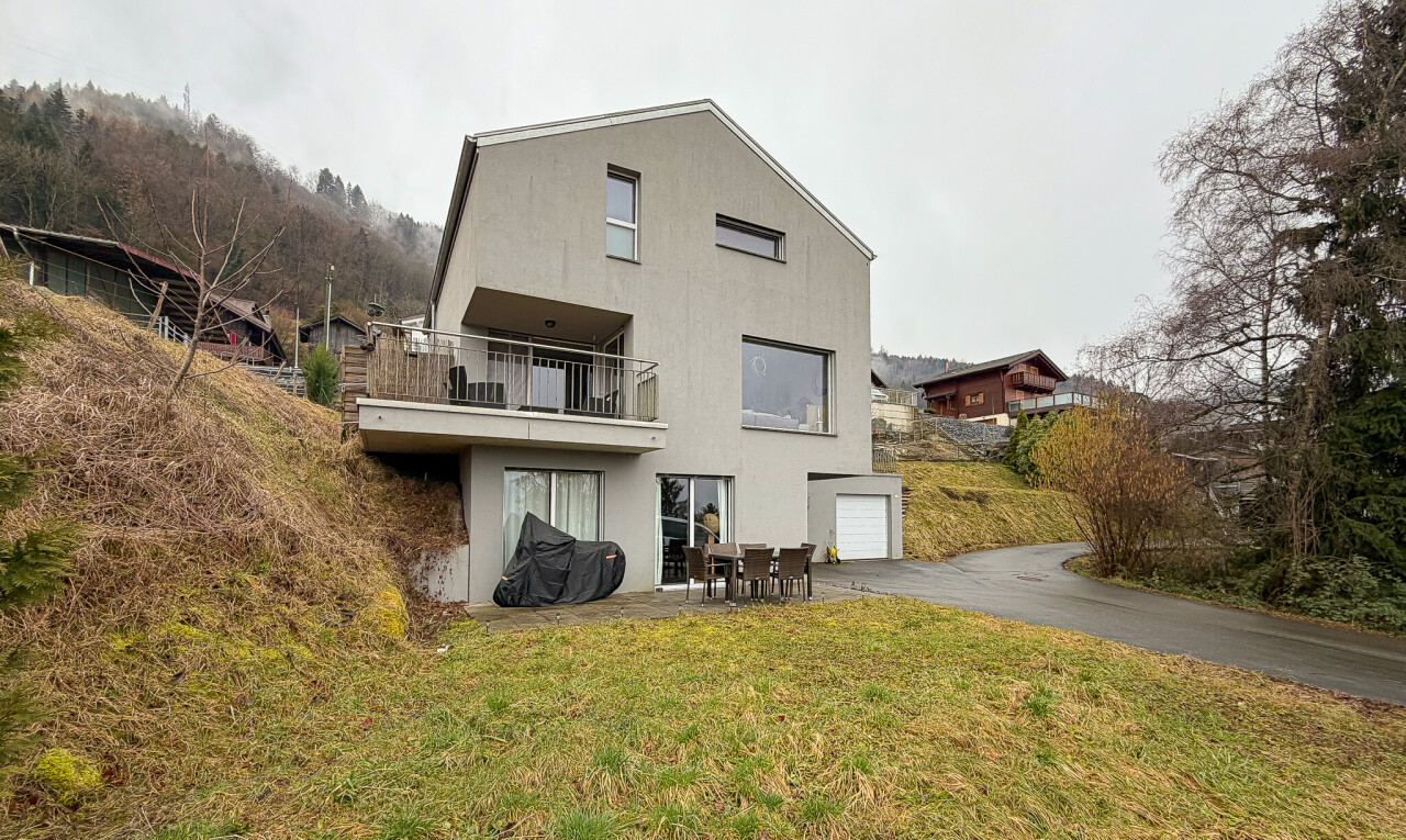 façade avec overcast, garage intégré, allée, balcon, et property visible