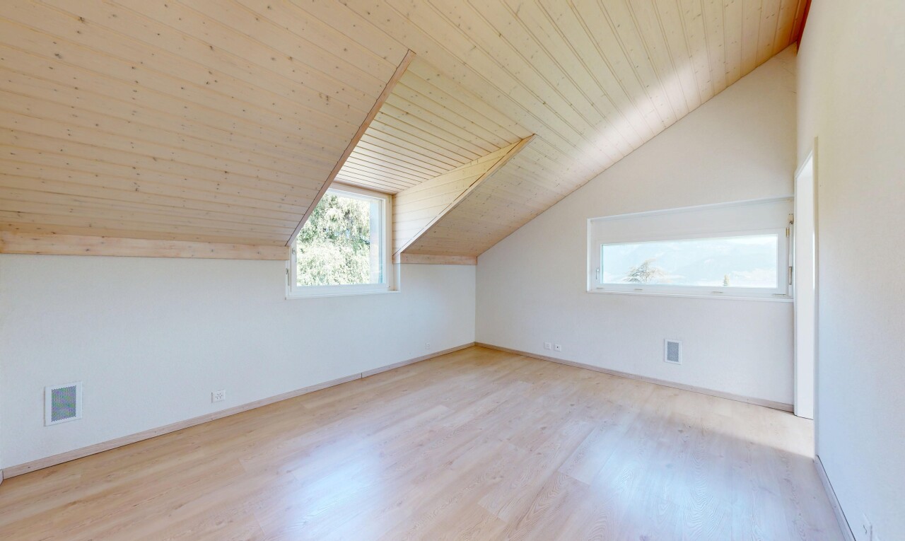 pièce vide avec inside property, pièce supplémentaire, plafond voûté, vaulted ceiling, et sol en finition bois
