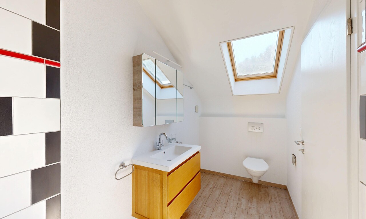 salle de bains avec plafond voûté, vaulted ceiling, lavabo (ou coiffeuse selon le contexte), light floor, et miroir