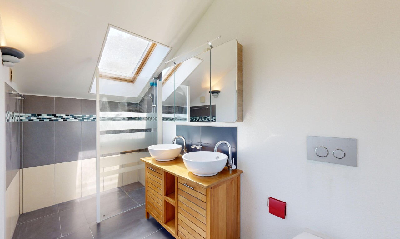 salle de bains avec douche, salle de bain complète, double vasque, miroir, et puits de lumière
