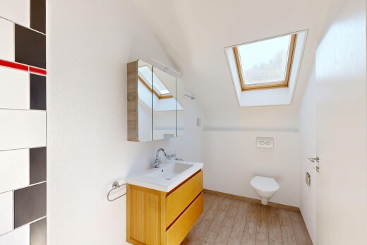 salle de bains avec plafond voûté, vaulted ceiling, lavabo (ou coiffeuse selon le contexte), light floor, et miroir