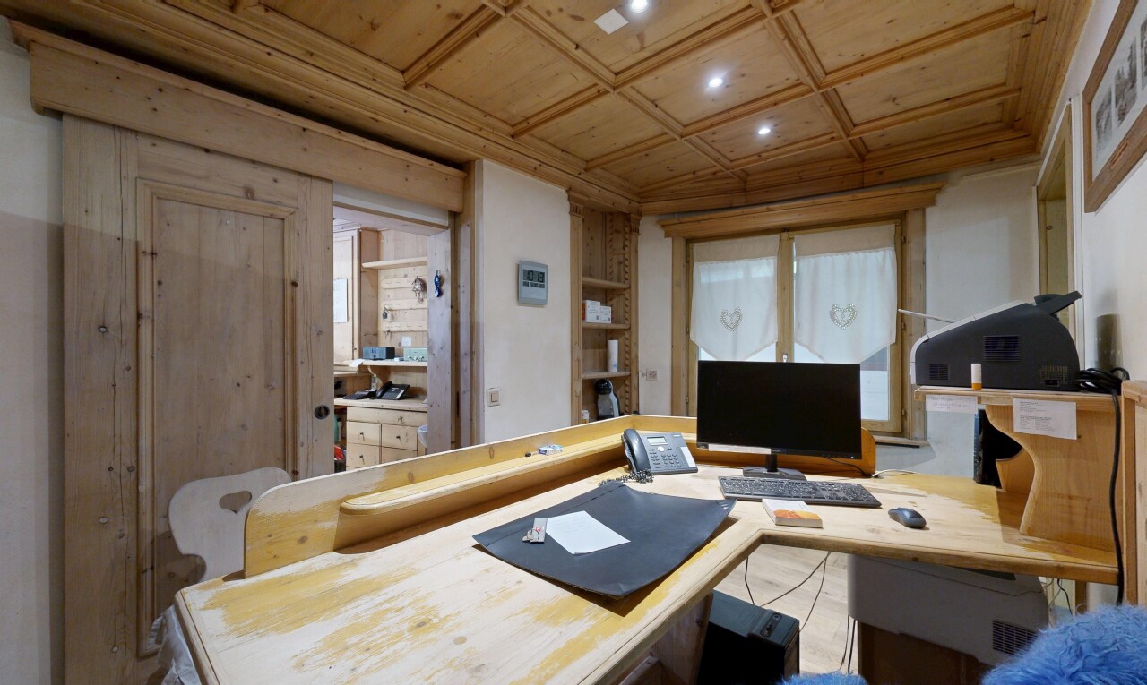 bureau avec wood ceiling, plafond en bois, étagères intégrées, télévision, et high end ceiling