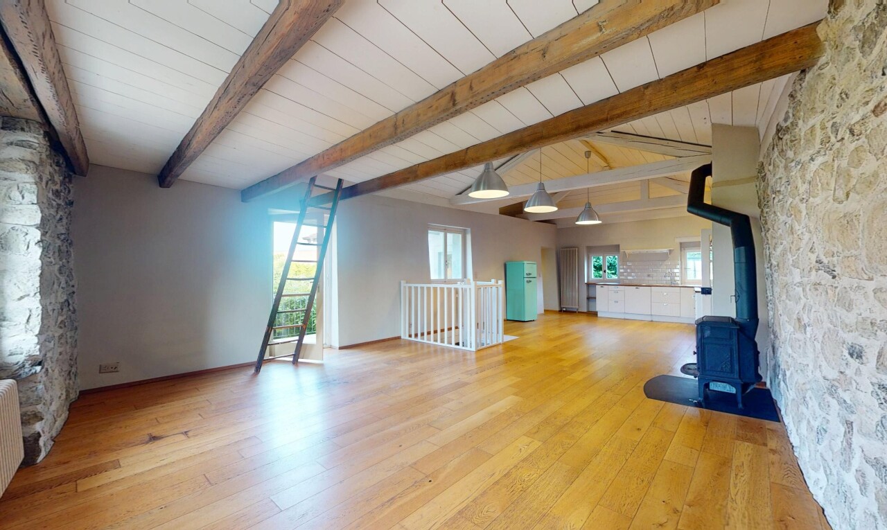 pièce vide avec mur en pierre, stone wall, poêle à bois, inside property, et plafond à poutres