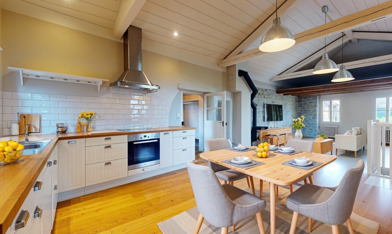 cuisine avec plans de travail en bois de boucher, hotte, poêle à bois, four, et évier