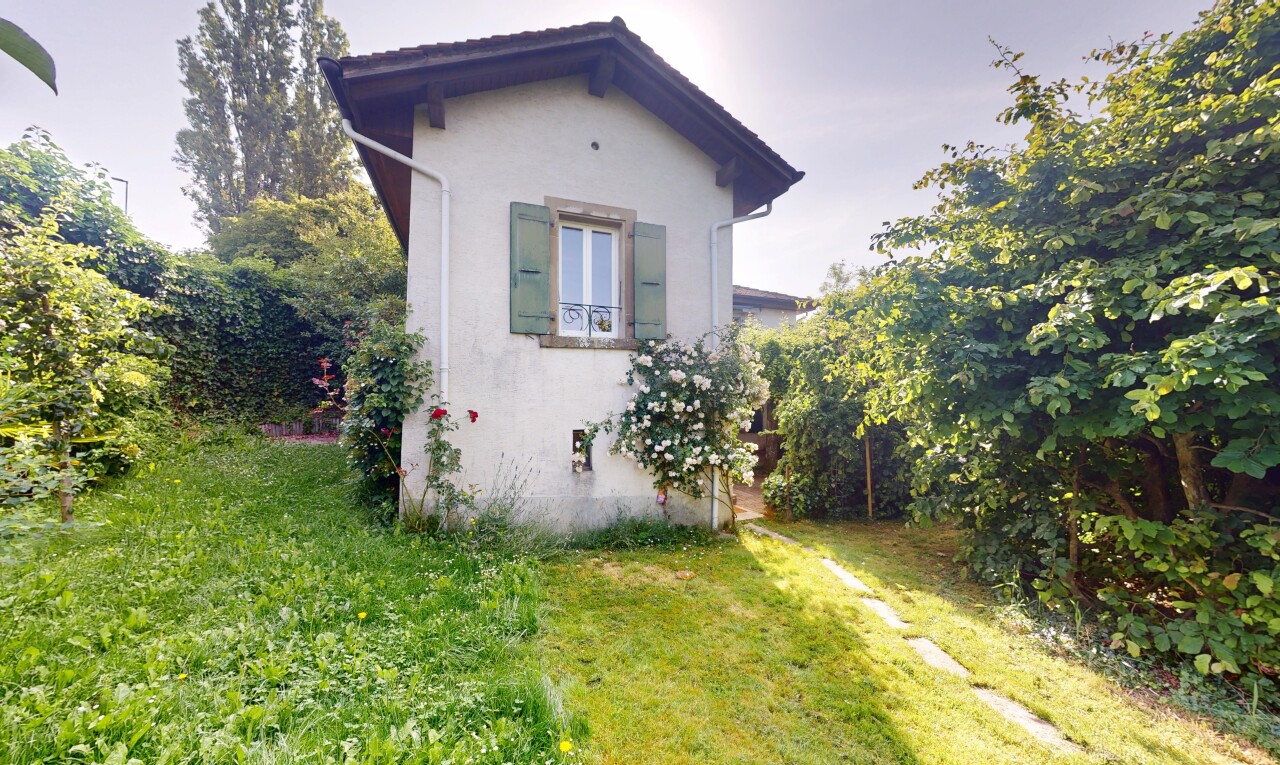 façade avec bardage en stuc, property visible, pelouse, et overcast
