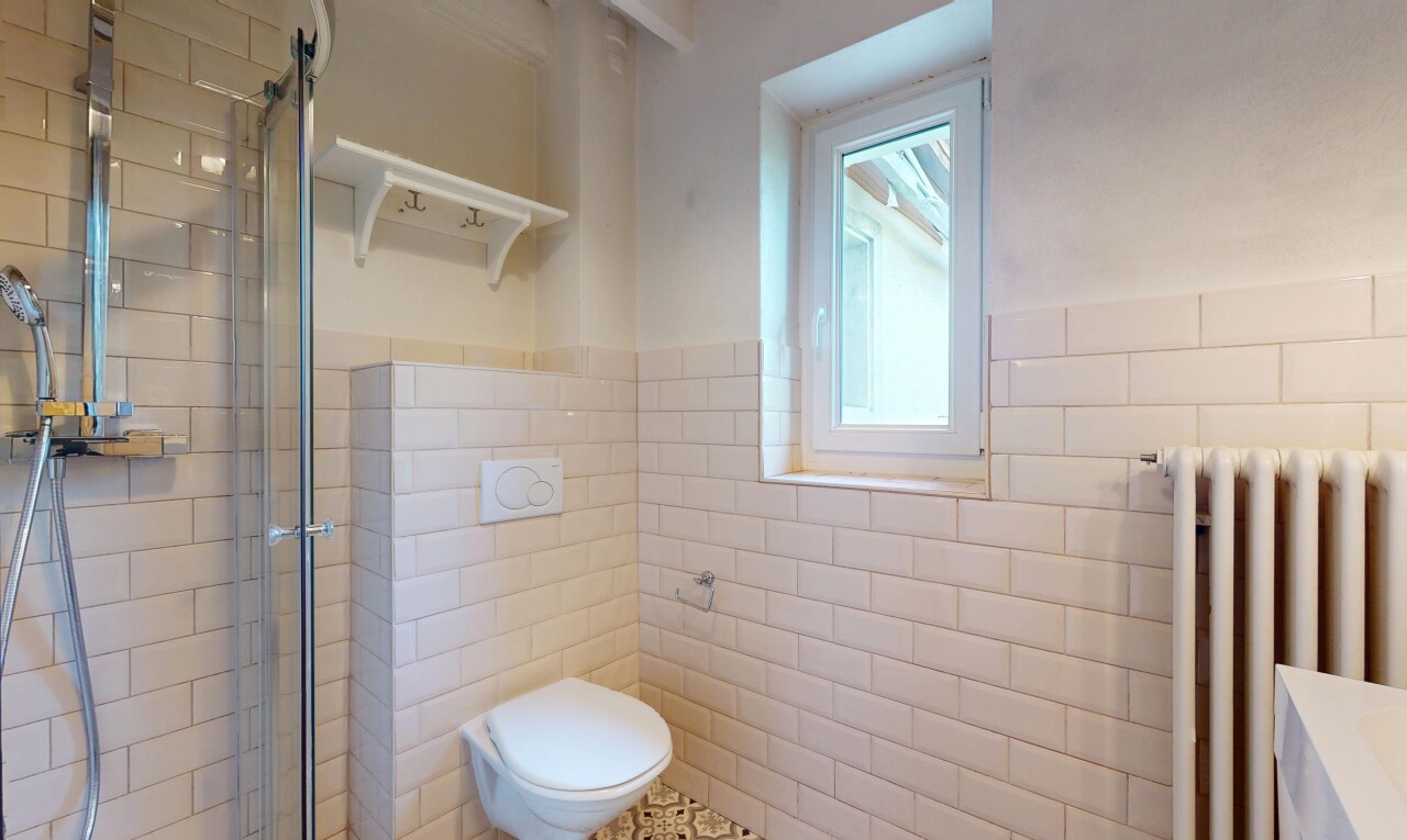 salle de bains avec radiateur, inside property, mur en carrelage, tile wall, et douche