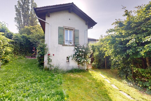 façade avec bardage en stuc, property visible, pelouse, et overcast