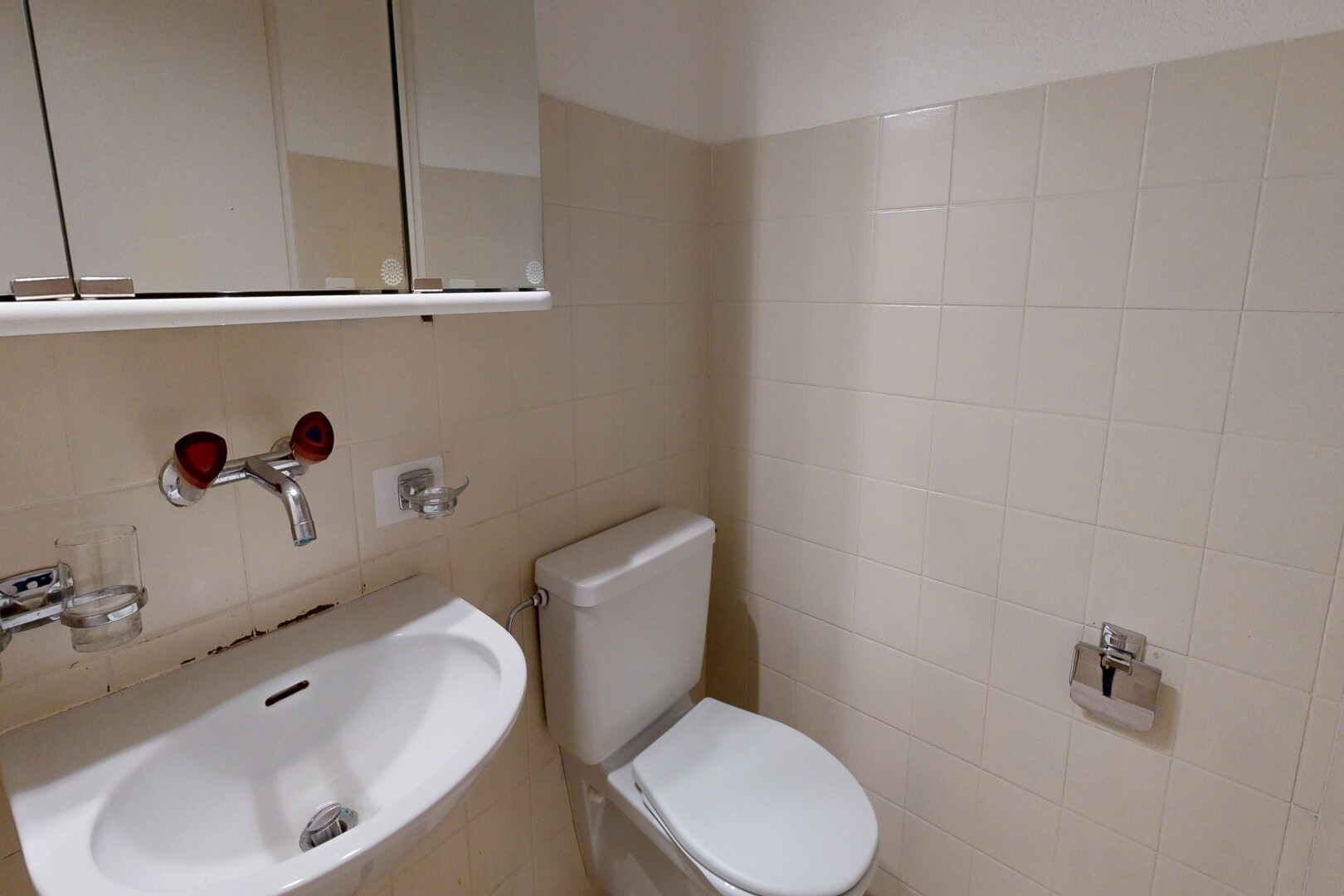 half bathroom featuring toilet and tile walls