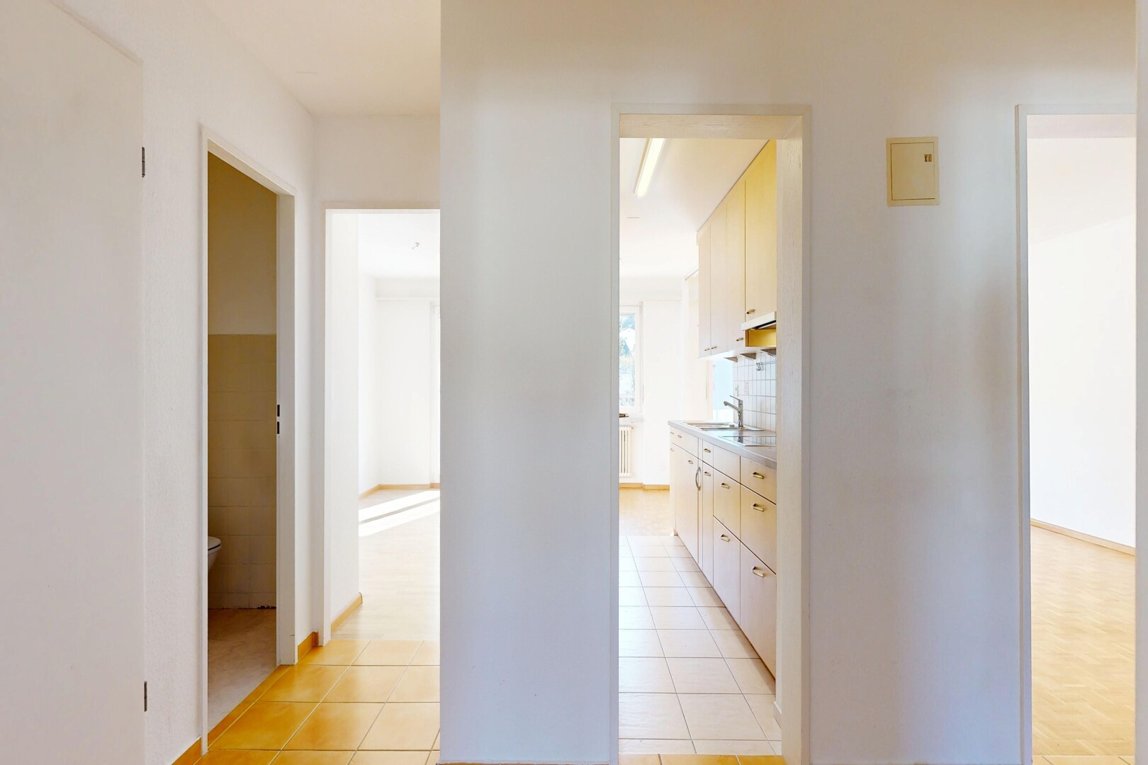 corridor with light tile patterned floors and a sink