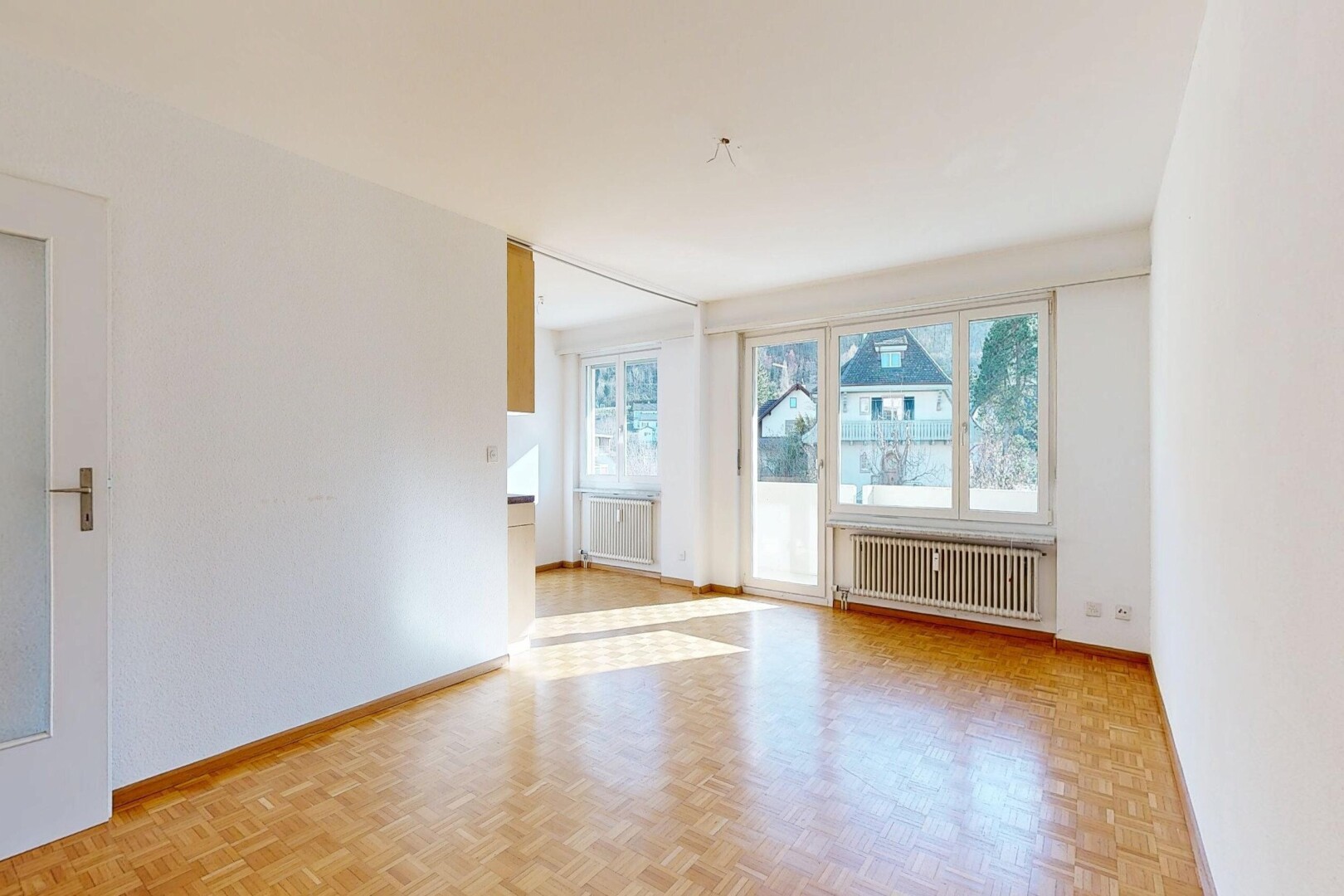 spare room featuring radiator and parquet flooring