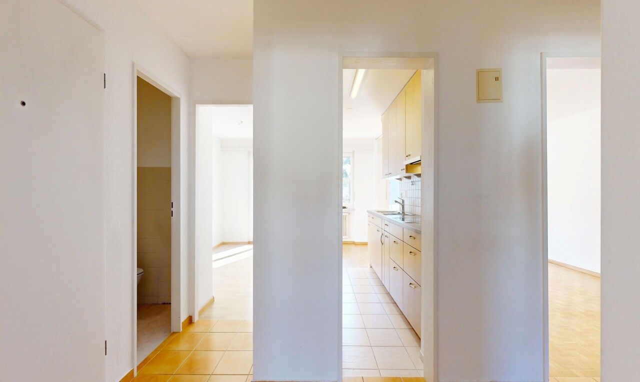 corridor with light tile patterned floors and a sink