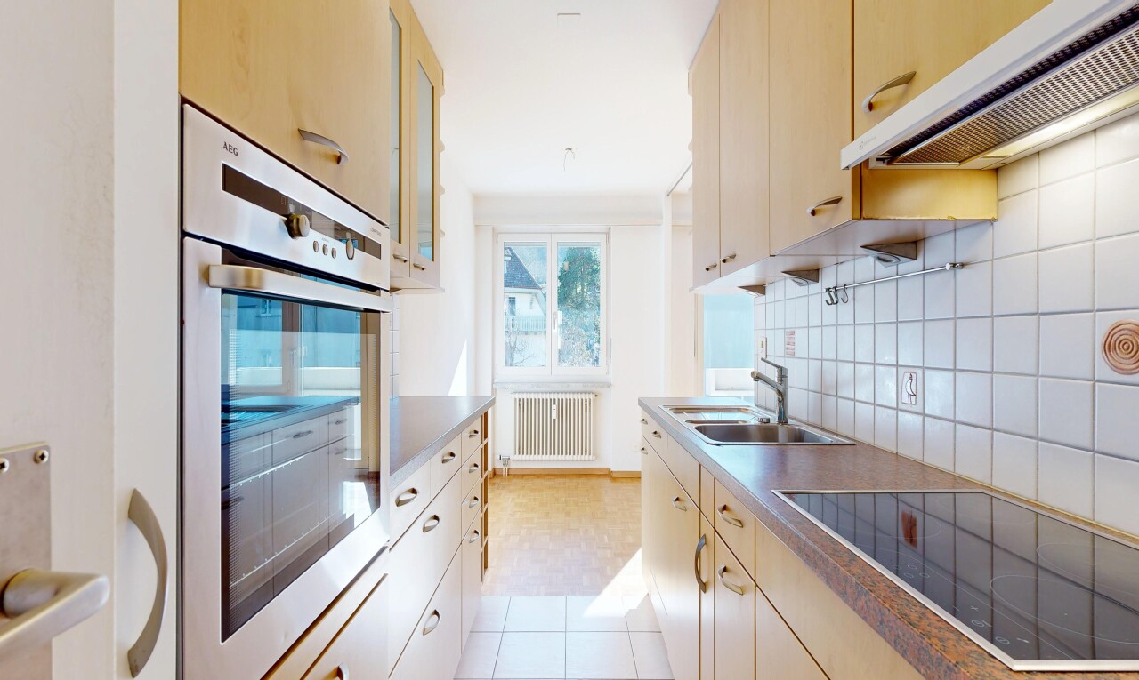 kitchen featuring oven, black electric cooktop, radiator, tasteful backsplash, and glass insert cabinets