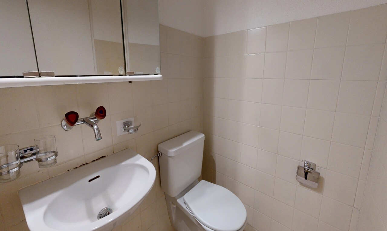 half bathroom featuring toilet and tile walls