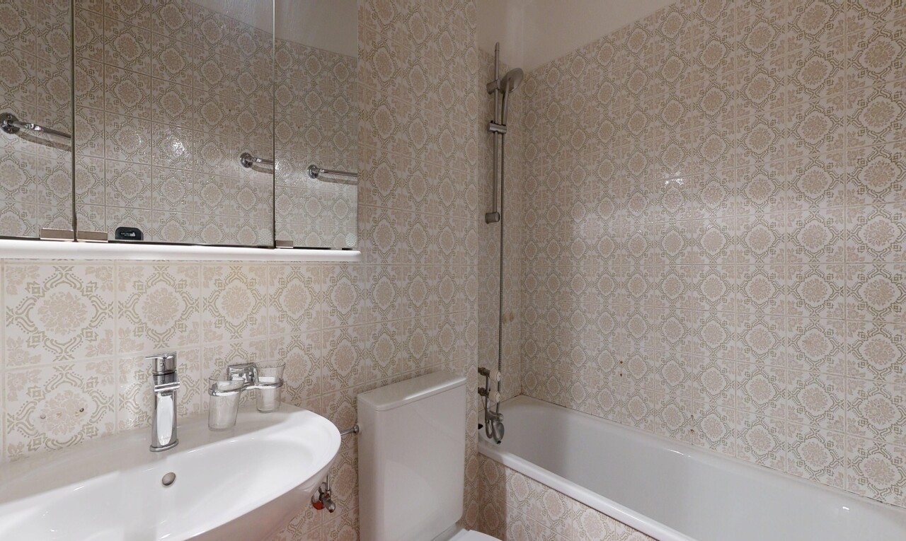 bathroom with a sink and tiled shower / bath combo
